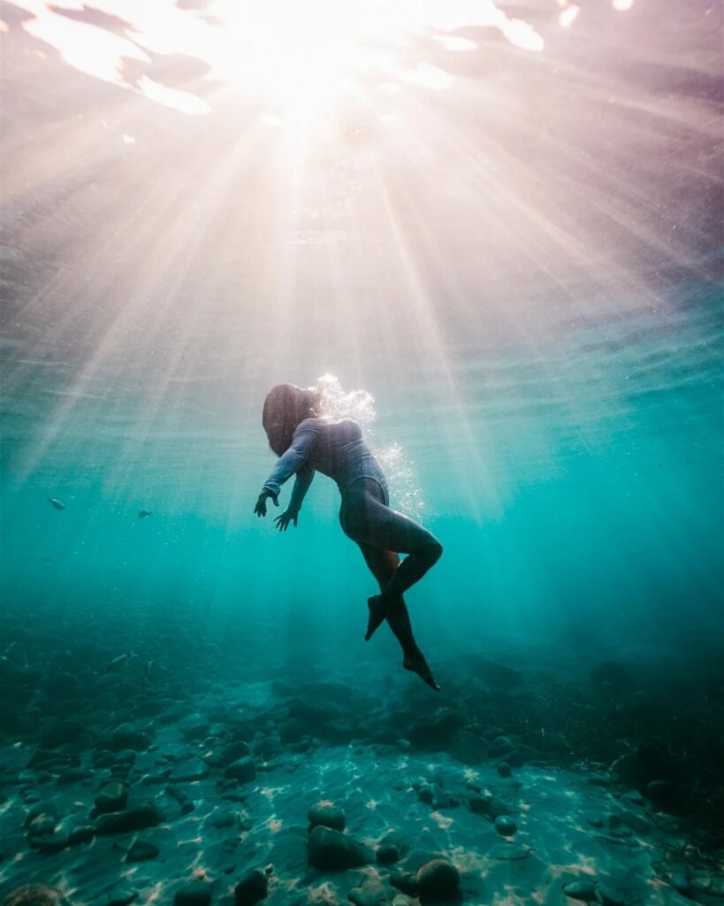 une femme sous l'eau photographié en mer avec une jolie lumiere