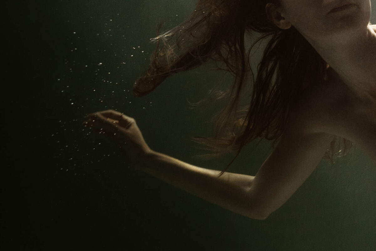 Artistic underwater portrait of a woman in a private pool